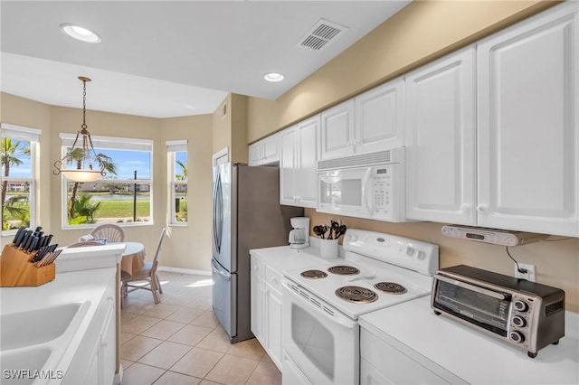 kitchen featuring white appliances, light countertops, visible vents, and white cabinetry