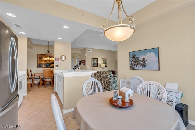 dining room with light tile patterned floors and a chandelier