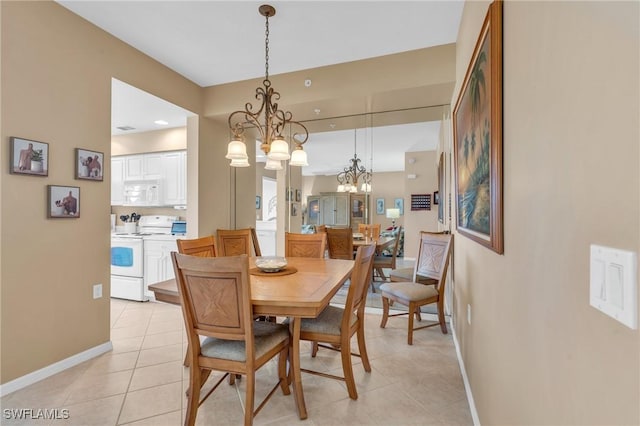 dining area with a chandelier and light tile patterned floors