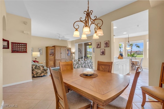 tiled dining area featuring ceiling fan with notable chandelier and plenty of natural light