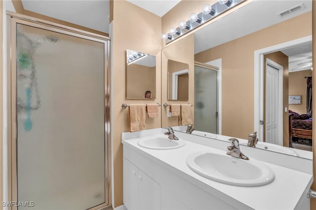 bathroom with vanity and a shower with door