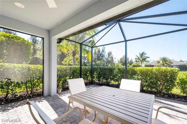 view of patio / terrace featuring ceiling fan and a lanai