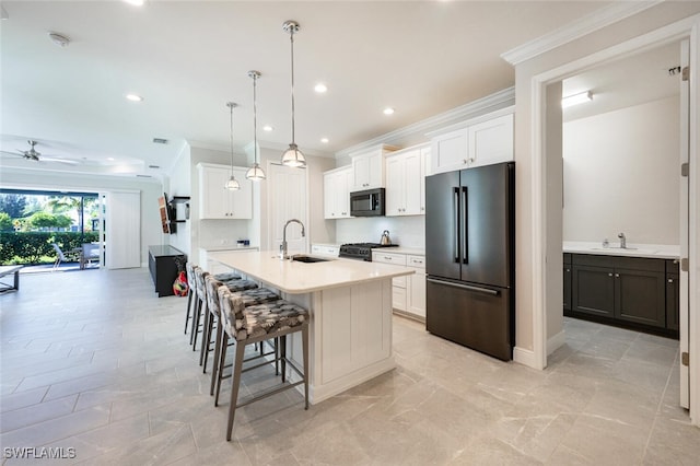 kitchen featuring ceiling fan, sink, black appliances, a center island with sink, and white cabinets