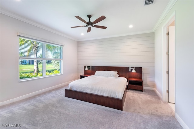 carpeted bedroom with ceiling fan and ornamental molding