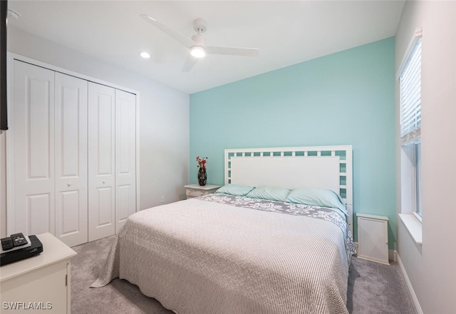 carpeted bedroom featuring ceiling fan and a closet