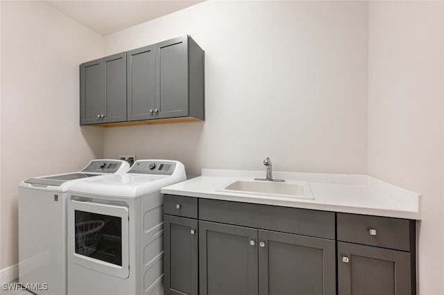 laundry room featuring washer and dryer, cabinets, and sink