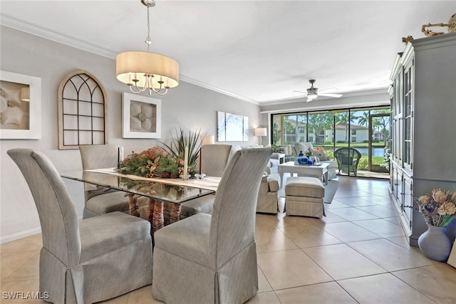 dining area featuring ceiling fan with notable chandelier, light tile patterned floors, and crown molding