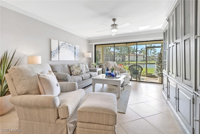 tiled living room with ceiling fan, a water view, and ornamental molding