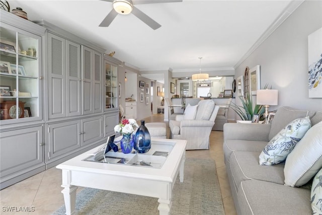 tiled living room with ceiling fan and crown molding