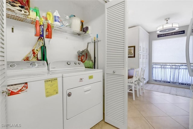 laundry room featuring light tile patterned flooring and separate washer and dryer