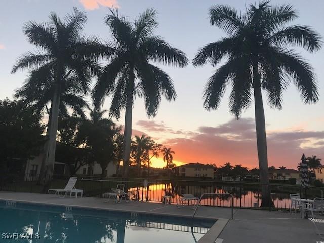 pool at dusk with a patio area