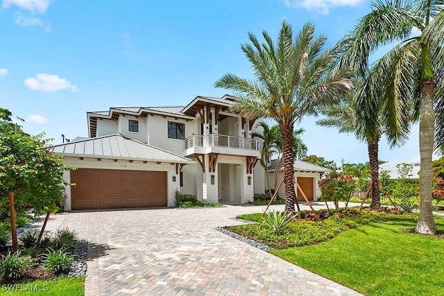 view of front of house featuring a balcony and a front lawn