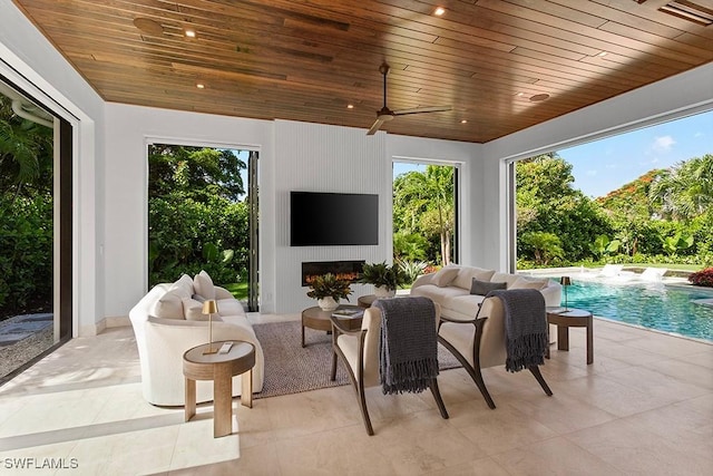 sunroom with plenty of natural light, a large fireplace, and wood ceiling