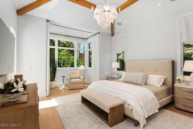 bedroom with a chandelier, beam ceiling, and light wood-type flooring