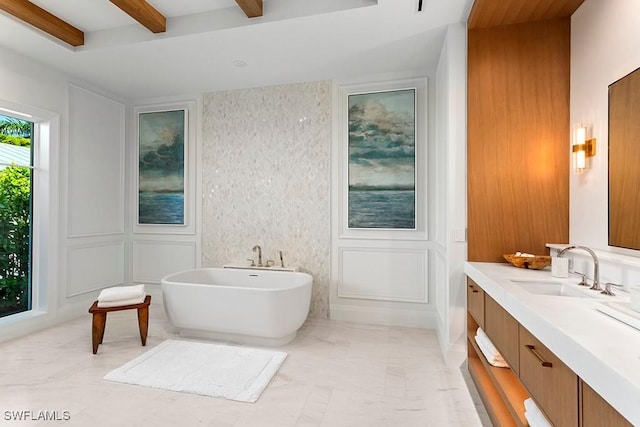 bathroom featuring beam ceiling, a bathtub, and vanity