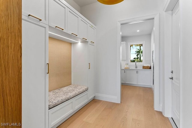 mudroom with light wood-type flooring and sink