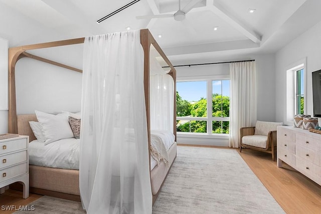 bedroom with ceiling fan, multiple windows, and light hardwood / wood-style flooring