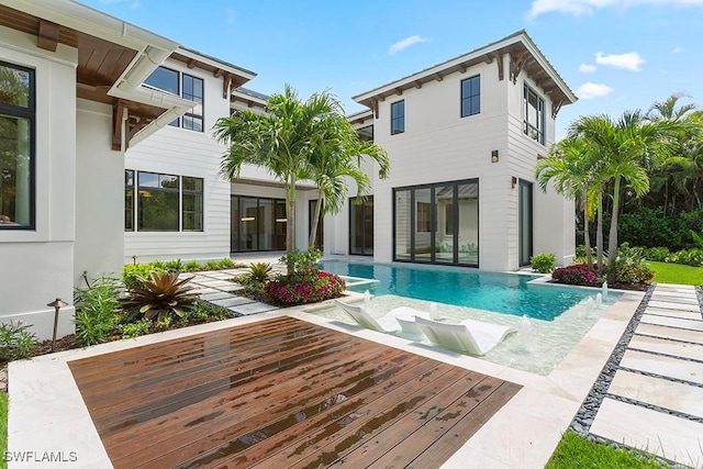 view of swimming pool with a wooden deck and pool water feature