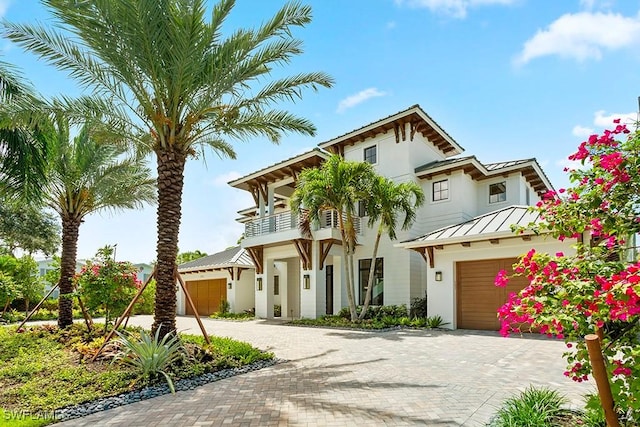 view of front of property featuring a balcony and a garage