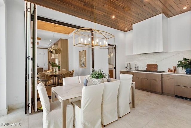 dining area featuring wood ceiling, sink, and a chandelier