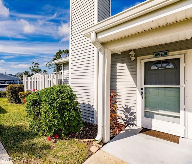 property entrance featuring a lawn