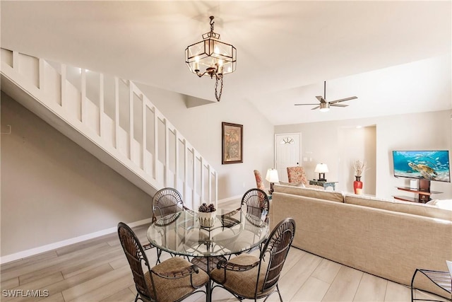 dining area featuring lofted ceiling, light hardwood / wood-style floors, and ceiling fan with notable chandelier