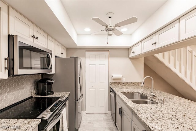 kitchen featuring light stone countertops, stainless steel appliances, white cabinets, and sink