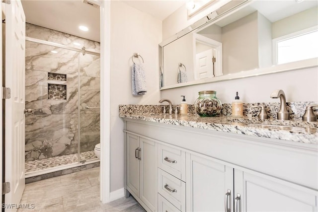 bathroom with vanity, toilet, and walk in shower