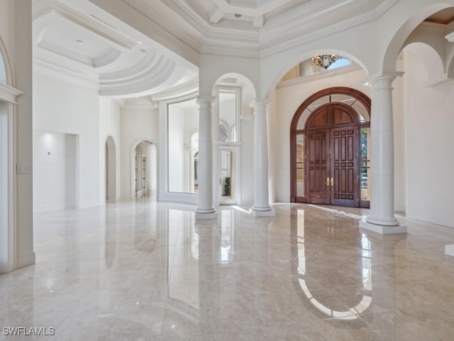 entrance foyer with decorative columns, marble finish floor, and a towering ceiling