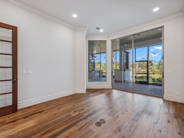 unfurnished room featuring recessed lighting, ornamental molding, baseboards, and hardwood / wood-style flooring