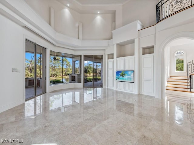 unfurnished living room featuring crown molding, stairway, baseboards, and marble finish floor