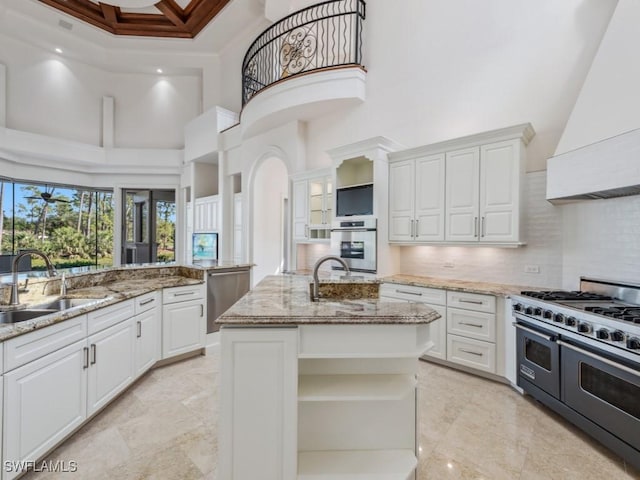 kitchen featuring a sink, double oven range, open shelves, exhaust hood, and white cabinets