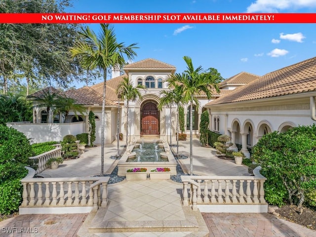 mediterranean / spanish house featuring stucco siding and a tiled roof