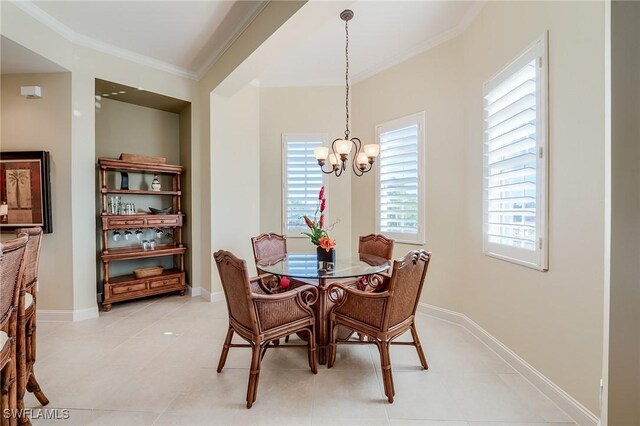 tiled dining area with crown molding and a notable chandelier