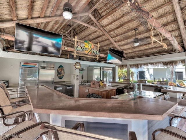 kitchen featuring vaulted ceiling with beams, stainless steel fridge, ceiling fan, and wooden ceiling