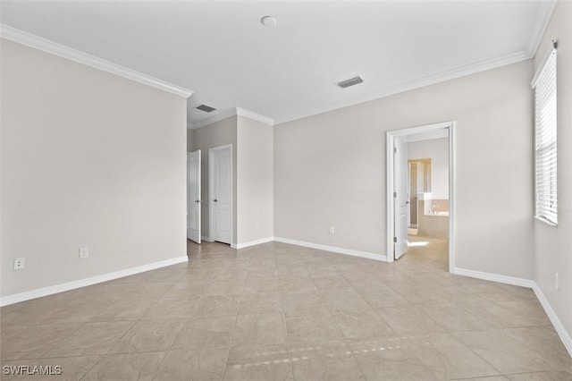 spare room featuring light tile patterned floors and crown molding