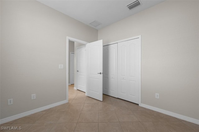 unfurnished bedroom featuring a closet and light tile patterned flooring