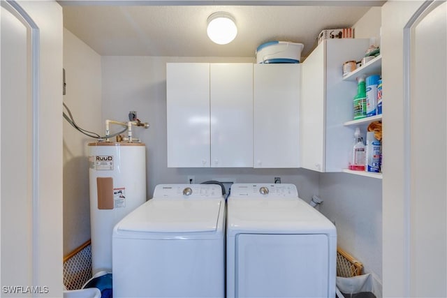 washroom with cabinets, washer and clothes dryer, and water heater