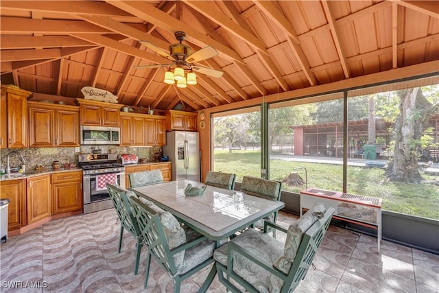 sunroom / solarium featuring a wealth of natural light, ceiling fan, sink, and lofted ceiling