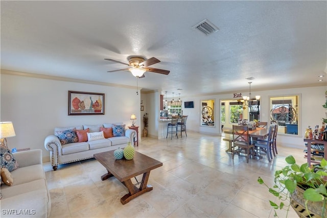 living room featuring ceiling fan with notable chandelier, ornamental molding, and a textured ceiling