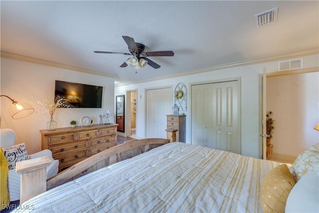 bedroom with ceiling fan, crown molding, and two closets