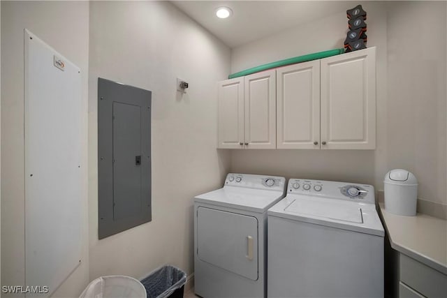 washroom with electric panel, separate washer and dryer, and cabinets