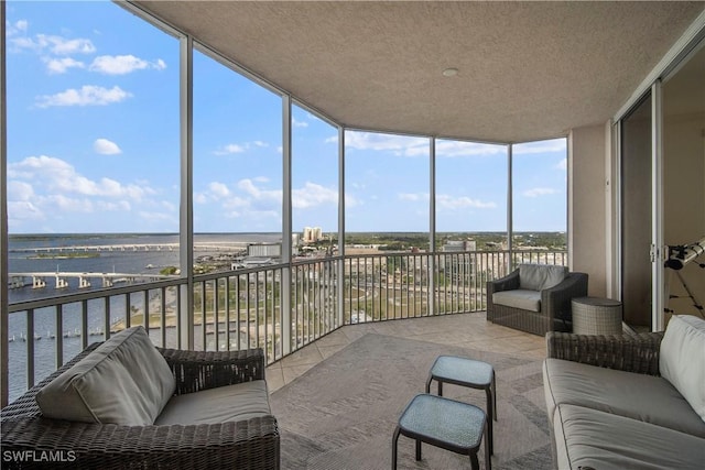 sunroom featuring a water view