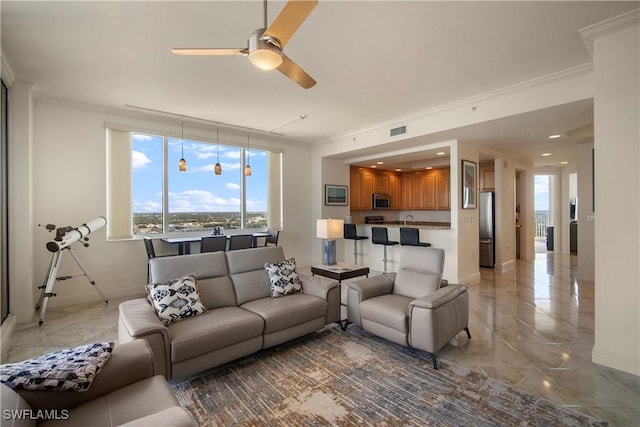 living room with ceiling fan and ornamental molding