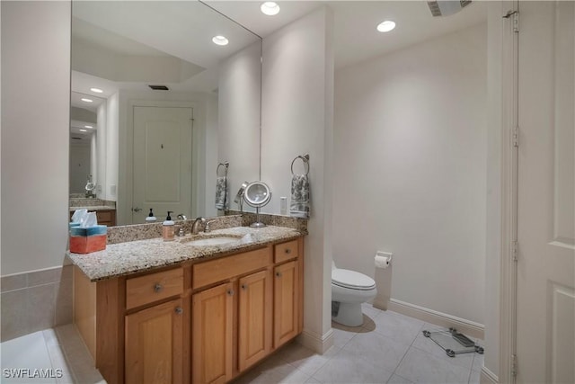 bathroom with toilet, vanity, and tile patterned floors