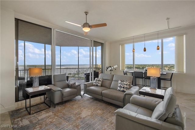 living room with ceiling fan and a water view