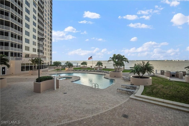 view of pool with a water view, a community hot tub, and a patio