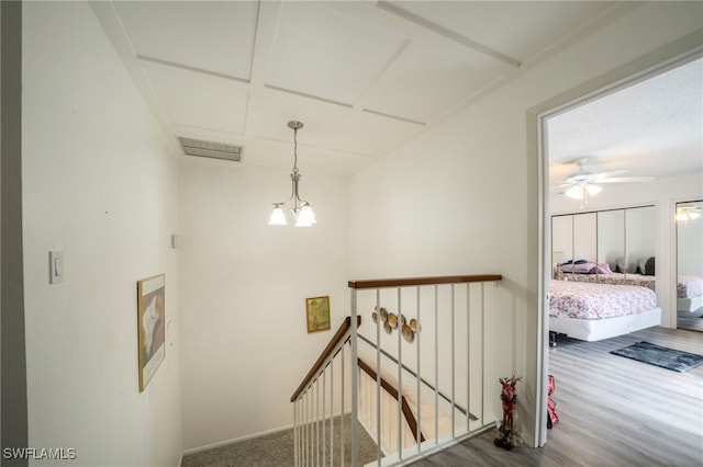 hallway featuring hardwood / wood-style flooring and a notable chandelier