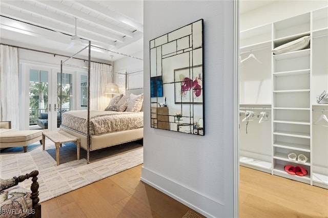 bedroom featuring hardwood / wood-style flooring, access to outside, french doors, and beamed ceiling