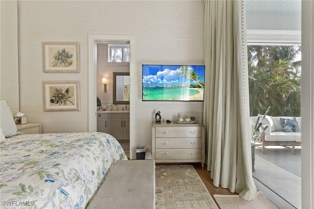 bedroom featuring hardwood / wood-style flooring and ensuite bath